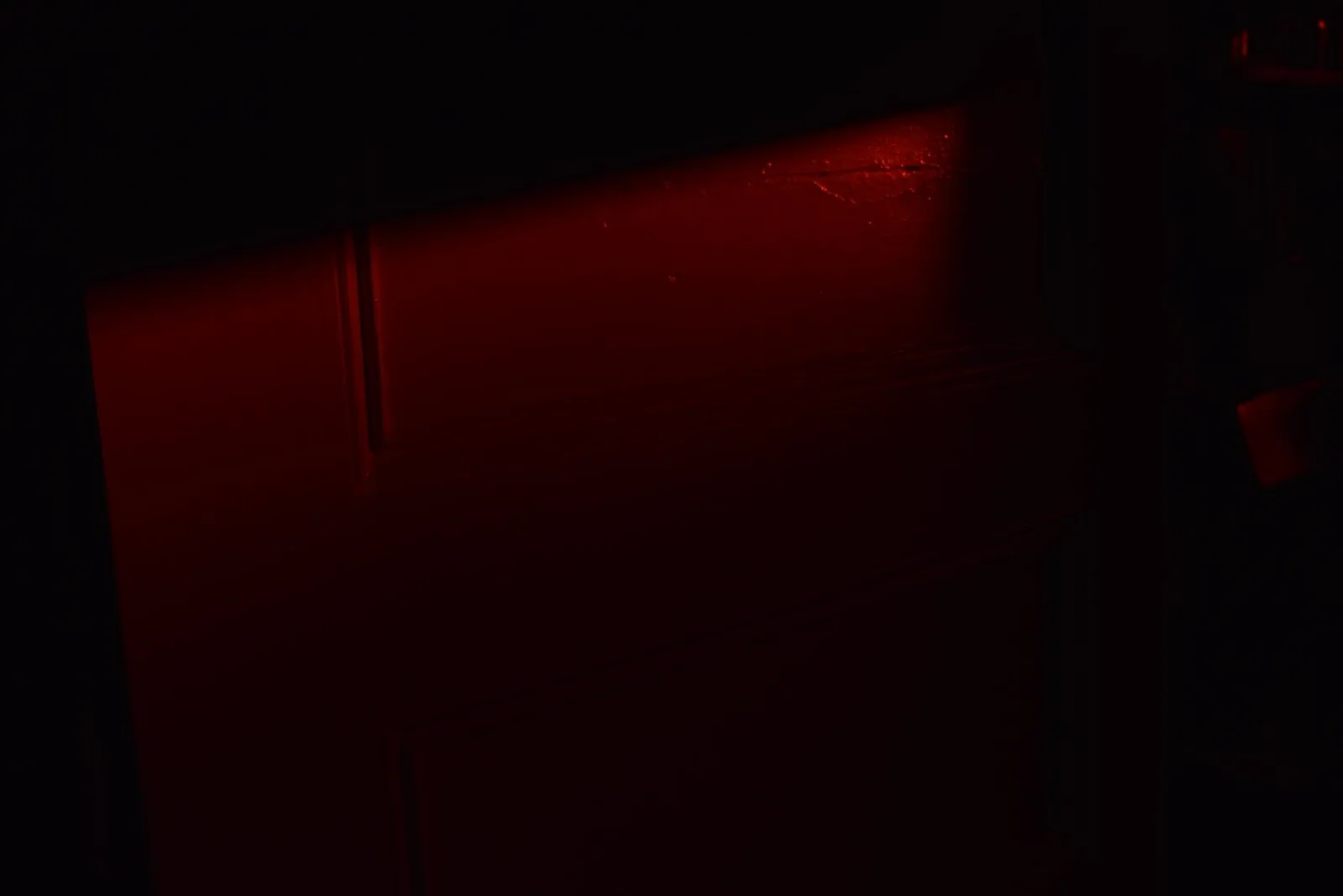 A red door barely visible in near darkness